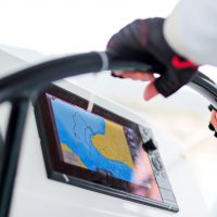 close-up of female hands at the helm of a yacht against the background of an echo sounder
