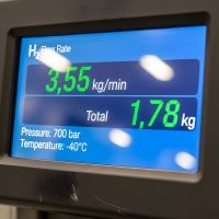 Close-up of a digital screen displaying real-time data for gas flow rate, total mass, pressure, and temperature.