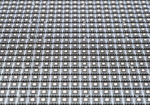 LED matrix outdoor screen close-up. Straight rows of LEDs on a modular panel. Limited depth of field.